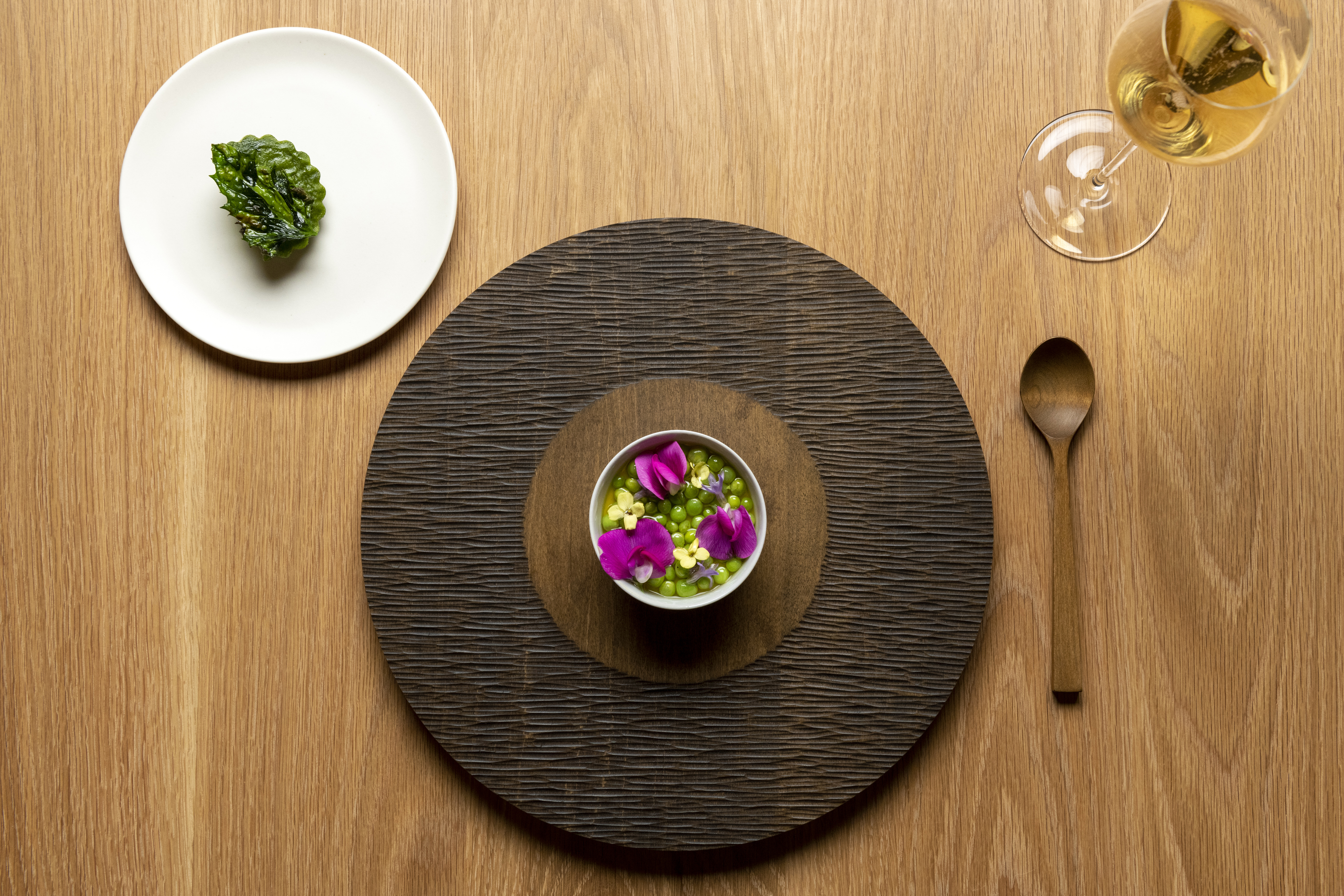 A bowl of peas is topped with edible flowers at Okta in McMinnville.