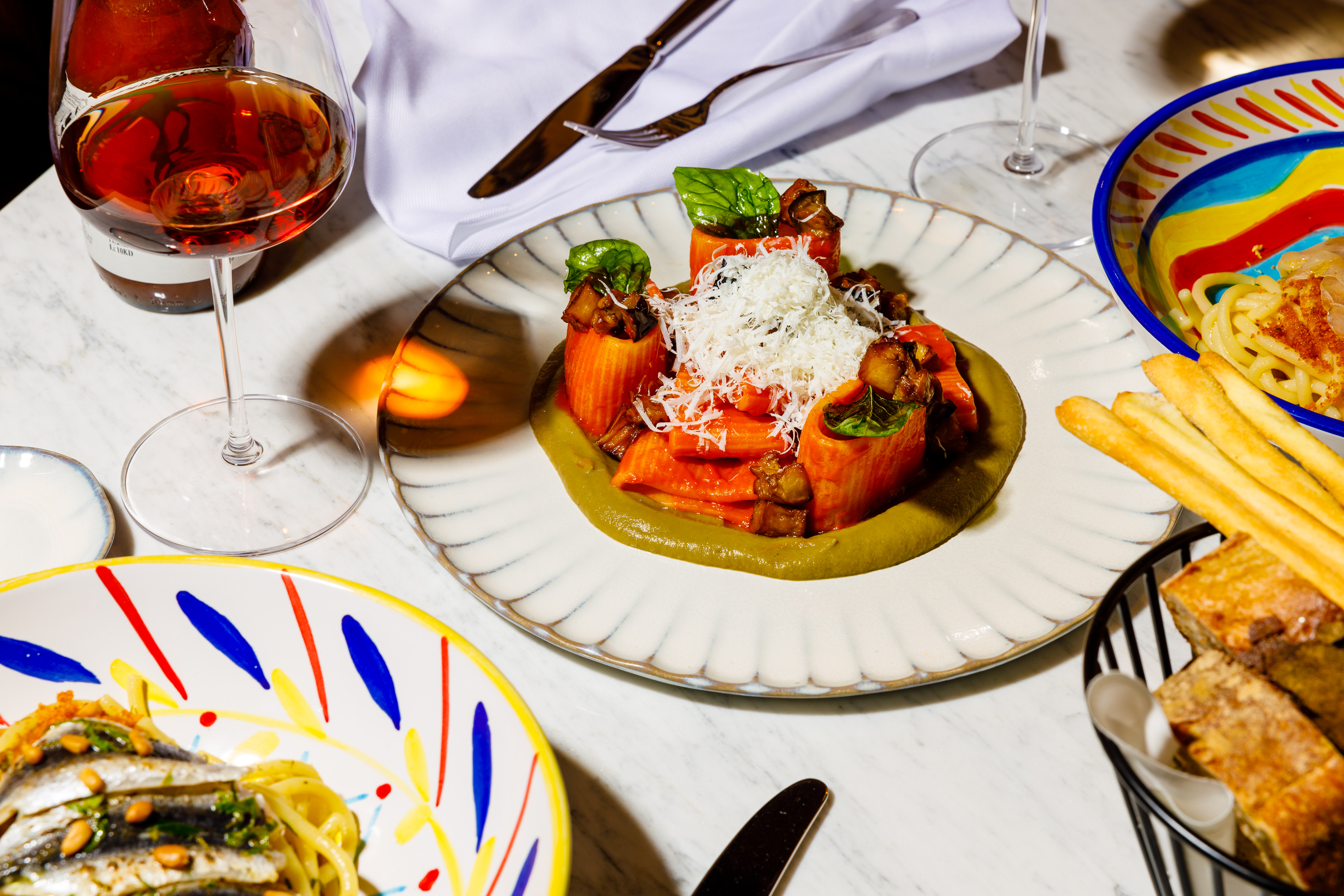 A spread of dishes including pasta and wine.