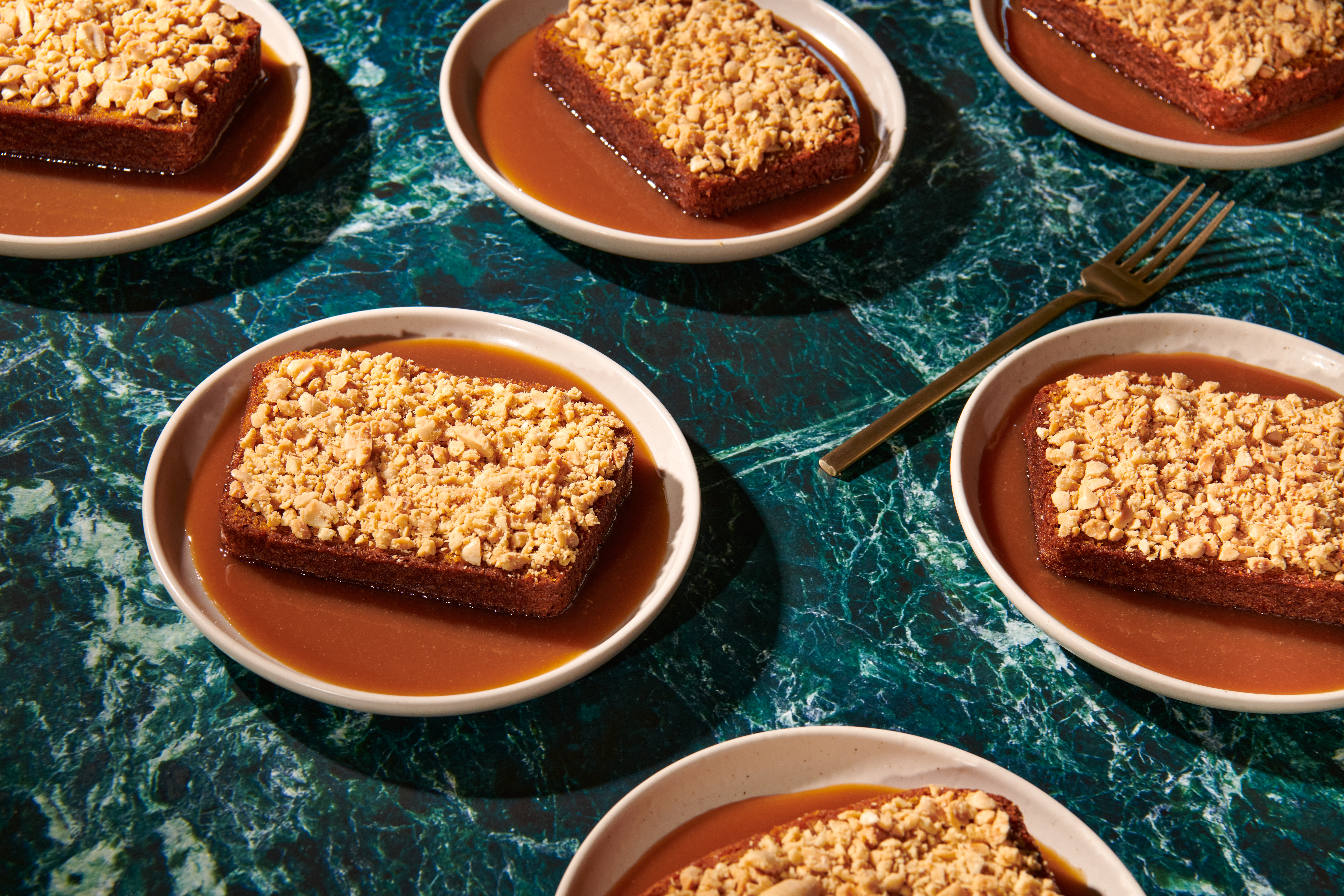 Slices of sweet potato bread in toffee sauce served on small pink plates.