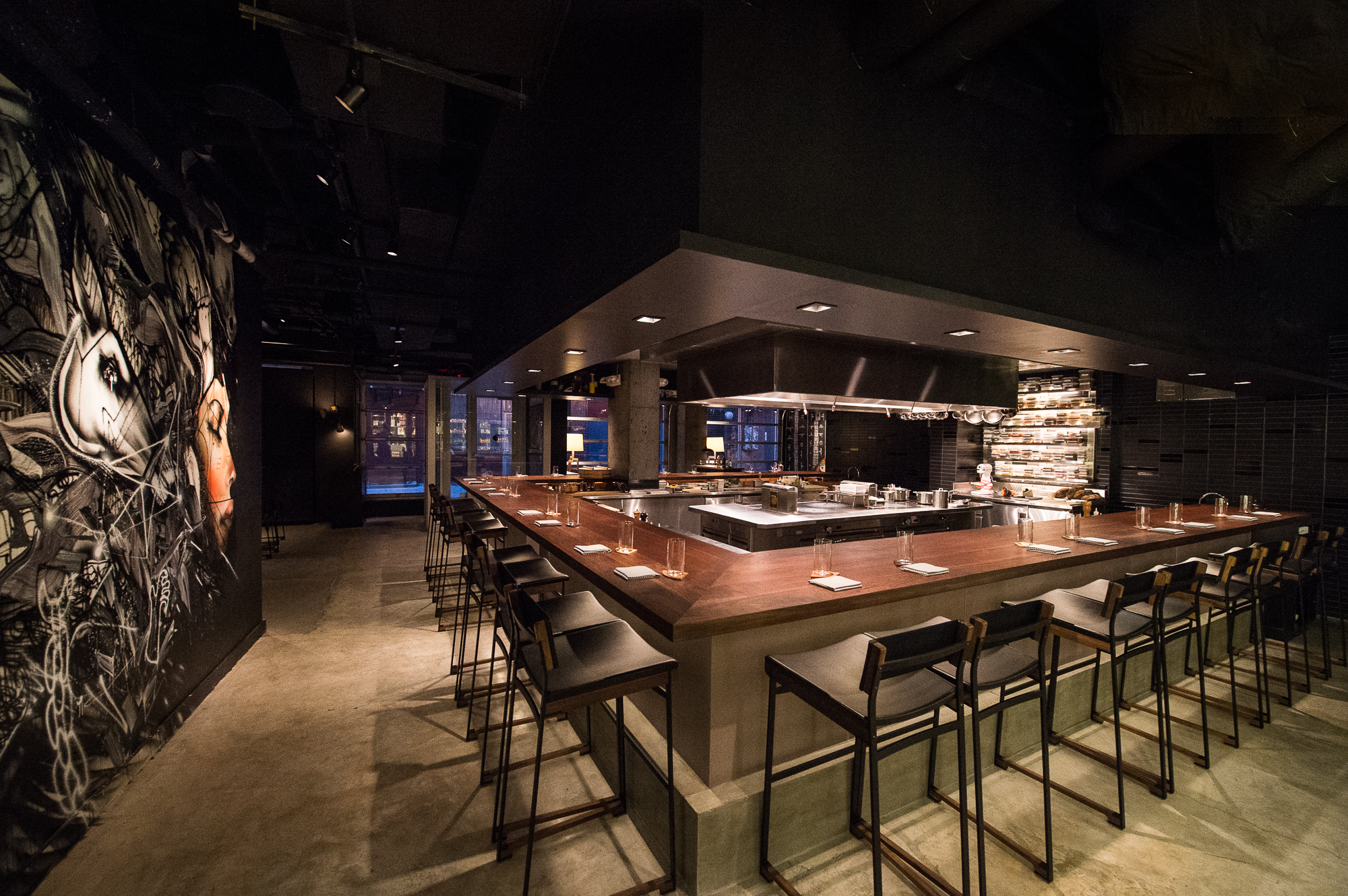 The dining room at Momofuku Ko with a big bar and moody lighting.