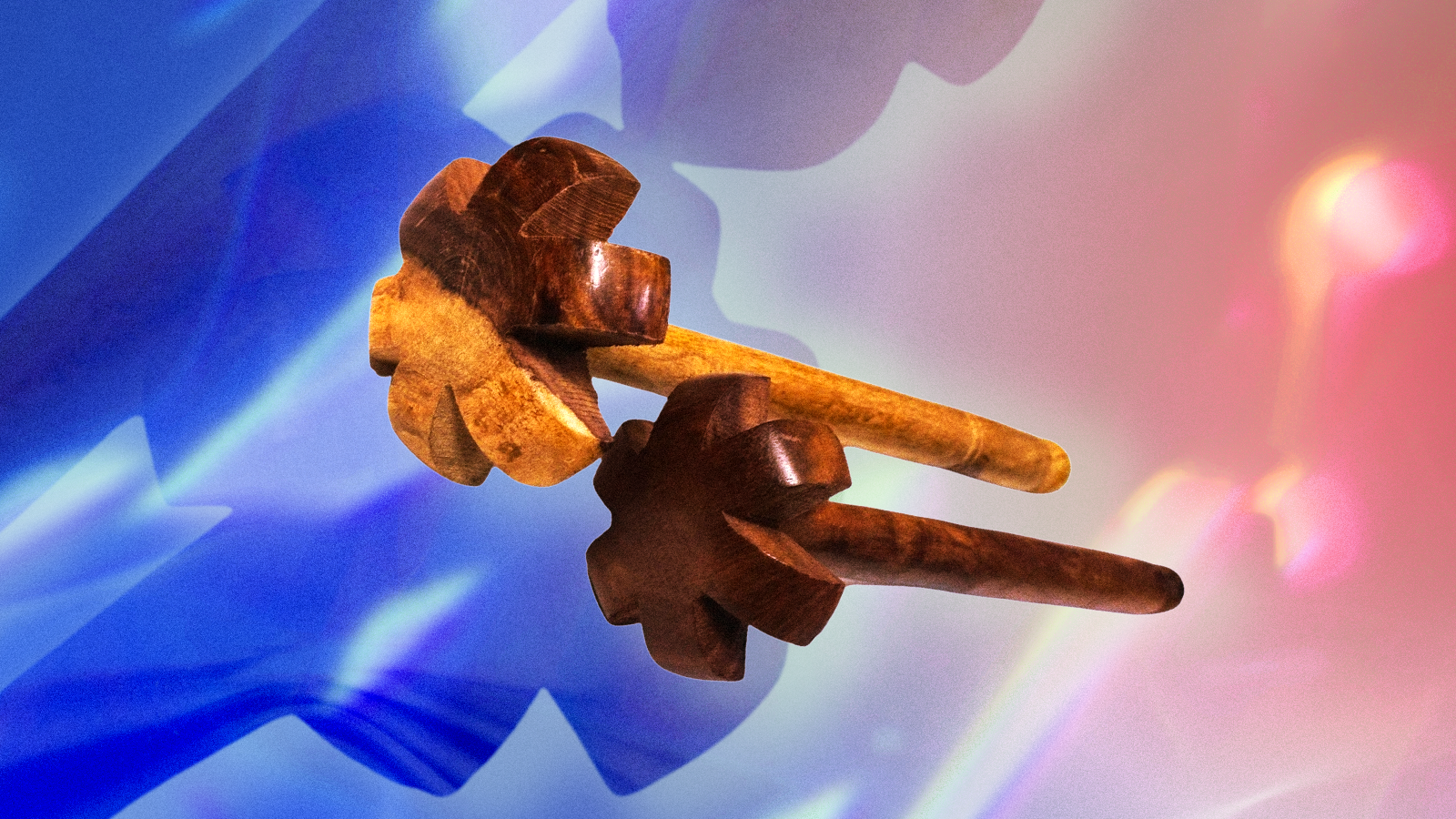 Two wooden churners against an abstract colorful red and blue background.